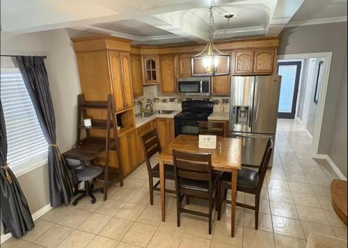 a kitchen with a table and a refrigerator and cabinets at 1 BR 1 Bath Airport SpaceX LNG WashDry Yard Patio Pets in Brownsville