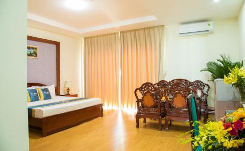 a bedroom with a bed and two chairs in it at Ninh Kieu Riverside Hotel in Can Tho