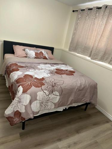 a bedroom with a bed with a floral bedspread at Joyful Home Regina in Regina