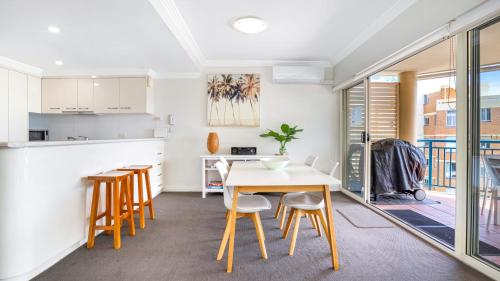 a kitchen and dining room with a table and chairs at Whitesands 501 in Forster