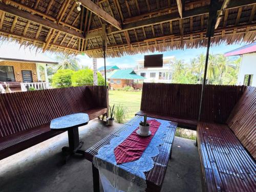 a porch with two benches and a table at Taylors Plantacion Resort- Bungalow Villa in Catarman