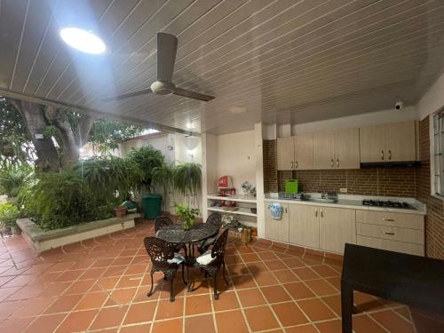 cocina con ventilador de techo, mesa y sillas en Casa Fenix, en Dibulla