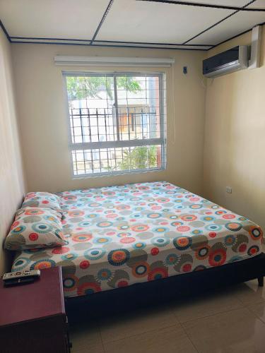 a bedroom with a bed in front of a window at Casa Fenix in Dibulla