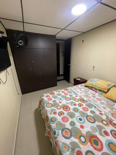 a bedroom with a bed with a colorful comforter at Casa Fenix in Dibulla