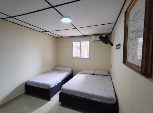 a room with two beds and a window at Casa Fenix in Dibulla