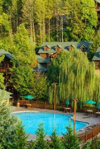 a swimming pool with tables and umbrellas in a resort at Westgate Smoky Mountain Resort & Spa in Gatlinburg