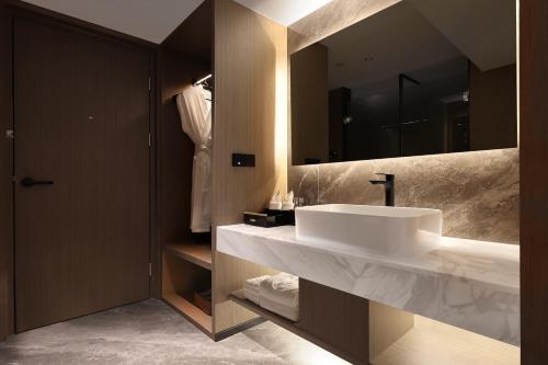 a bathroom with a white sink and a mirror at Guangzhou Huayu Wanfu Hotel-Free Shuttle Bus to Canton Fair Complex During Canton Fair Period in Guangzhou