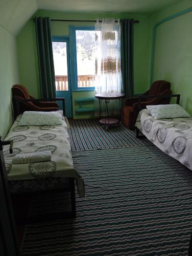 a room with two beds and a window at Syrgak in Dzhergalan