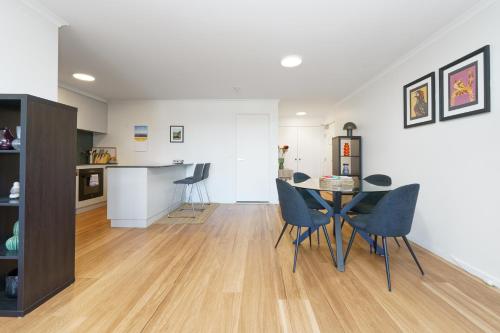 a dining room and living room with a table and chairs at Modern 2BR Balcony with Views and Close to City - Hosted by Canstay in Braddon