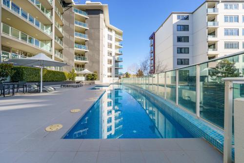 a swimming pool in front of a building at Modern 2BR Balcony with Views and Close to City - Hosted by Canstay in Braddon