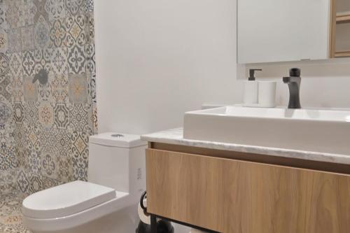 a bathroom with a white toilet and a sink at Marsellesa in Guadalajara