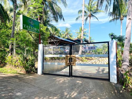 a gate with a sign in front of a resort at Taylors Plantacion Resort- Grande Second Floor in Catarman