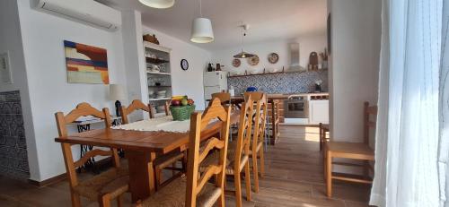 a kitchen and dining room with a wooden table and chairs at Casa Cor do Vinho in Vila de Frades