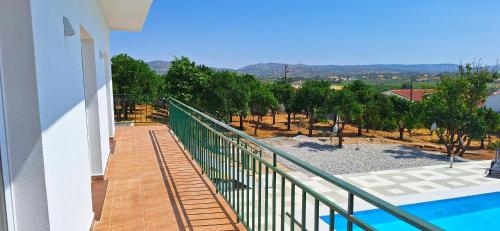 a balcony of a house with a pool and trees at Casa Cor do Vinho in Vila de Frades