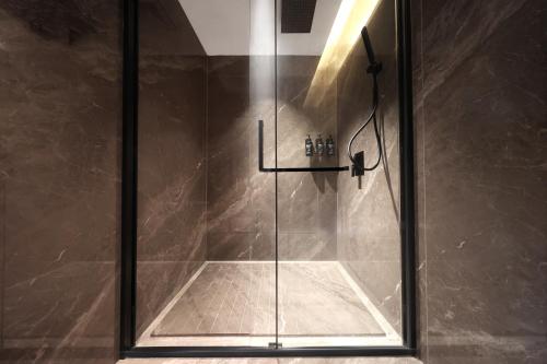 a shower with a glass door in a bathroom at Guangzhou Huayu Wanfu Hotel-Free Shuttle Bus to Canton Fair Complex During Canton Fair Period in Guangzhou