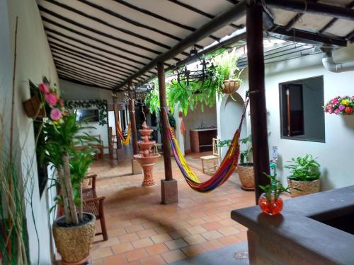 a patio with a hammock and potted plants at Habitación 4 personas Hostal centro San Gil in San Gil