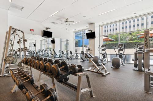 a gym with cardio equipment and a large window at City View Downtown Dallas High Rise Condo with Free Parking, Gym, Pool in Dallas
