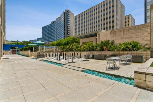 a patio with chairs and tables and buildings at City View Downtown Dallas High Rise Condo with Free Parking, Gym, Pool in Dallas