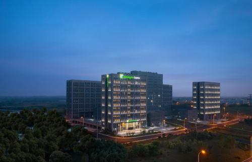 a group of tall buildings in a city at night at Holiday Inn Express Rongcheng Science and Technology Park in Rongcheng