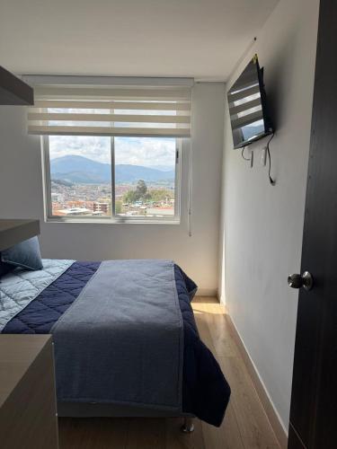 a bedroom with a bed and a large window at Confort 203 Apartamento Duitama in Duitama