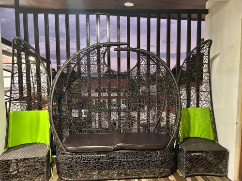 two chairs sitting on a balcony with green cushions at Sv hotspring resort in Calamba