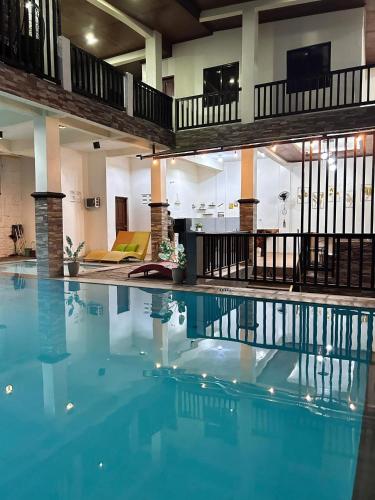 a large swimming pool with blue water in a building at Sv hotspring resort in Calamba