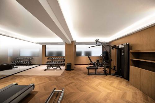 a gym with several treadmills and benches in a room at Guangzhou Huayu Wanfu Hotel-Free Shuttle Bus to Canton Fair Complex During Canton Fair Period in Guangzhou
