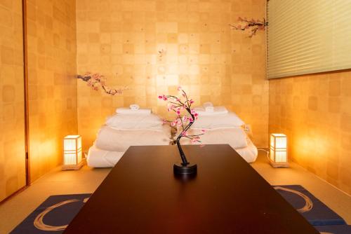 a room with a table with a bunch of mattresses at Stay KobeB in Kobe