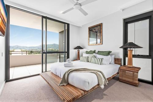 a bedroom with a large bed and a balcony at Boutique City Apartment in Coffs Harbour