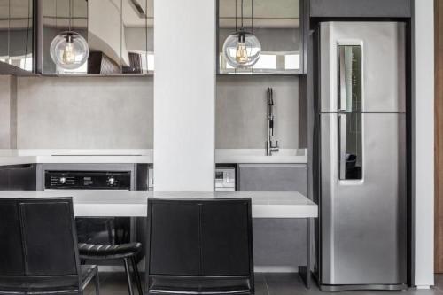 a kitchen with a refrigerator and a counter with chairs at Beach Loft next to the Sheraton Leblon in Rio de Janeiro