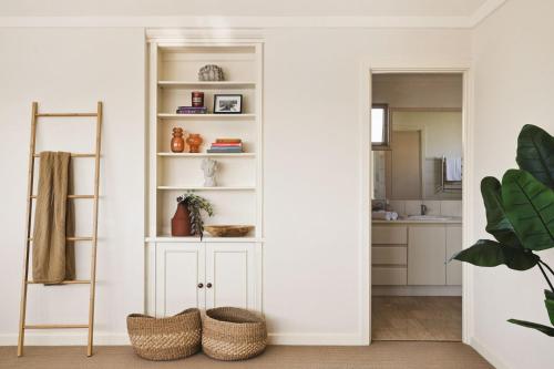 a kitchen with white walls and white shelves at Coastal Retreat-Spacious 4BR Walk to Beach in Perth