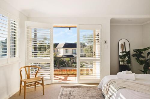 a bedroom with a bed and a chair and a window at Coastal Retreat-Spacious 4BR Walk to Beach in Perth