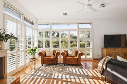 a living room with two chairs and a flat screen tv at Coastal Retreat-Spacious 4BR Walk to Beach in Perth