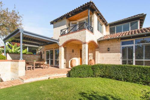 a house with a patio and a table on a lawn at Coastal Retreat-Spacious 4BR Walk to Beach in Perth