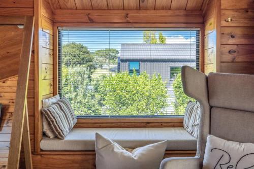 a window in a room with a couch and a chair at Hartlock in Onetangi in Waiheke Island