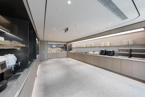 a large kitchen with a long hallway in a restaurant at JI Hotel Beijing Fangshan Commercial Street in Beijing