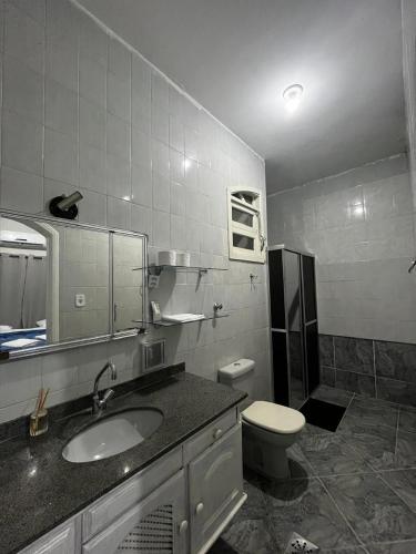 a bathroom with a sink and a toilet at Casa Vitória in Aparecida