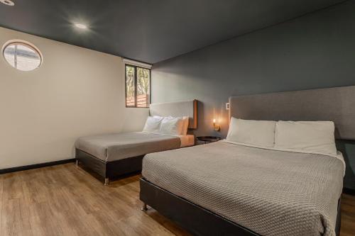 a small bedroom with two beds and a window at Soy Local Parque La 93 in Bogotá