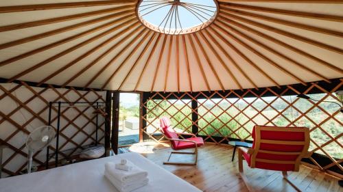 a yurt with a table and two chairs and a window at Awaawa Yurts - Papatūānuku in Waiheke Island