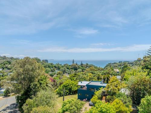 an aerial view of a blue house in the trees at Casa Del Mar in Waiheke Island