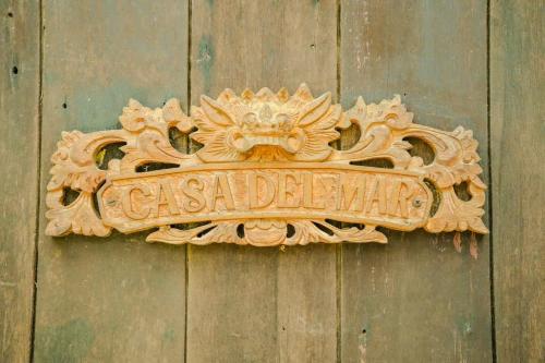 a sign on the side of a wooden wall at Casa Del Mar in Waiheke Island