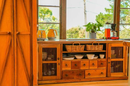 a wooden cabinet with dishes on it in a room at Casa Del Mar in Waiheke Island