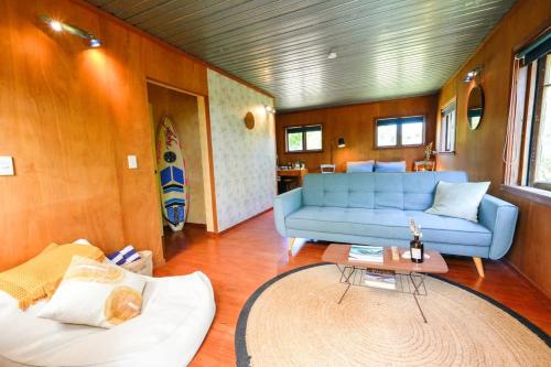 a living room with a blue couch and a table at Casa Del Mar in Waiheke Island
