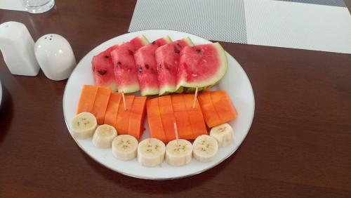 a plate with sliced bananas and fruit on a table at Kandy Alpine Breeze in Kandy