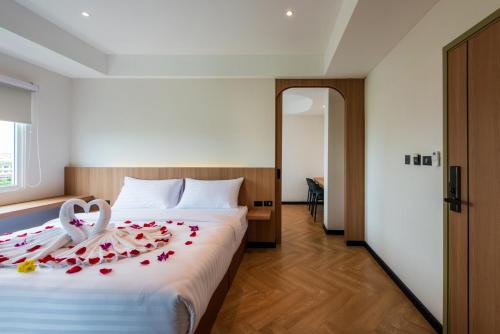 a hotel room with a bed with roses on it at The Moment Hotel in Ban Bang Khan