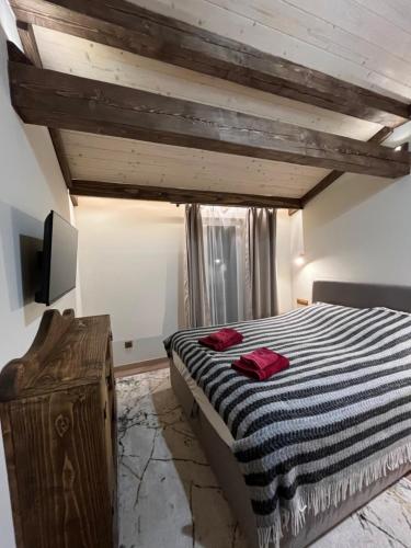 a bedroom with a bed with a black and white striped blanket at Family Plai in Yaremche