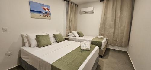 a room with two beds and a window at Cabañas Jardín del mar - By Amauna in San Bernardo del Viento