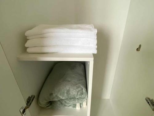 a group of towels on a shelf in a bathroom at Cozy Stay with 2beds-Gentry 2mins to Okada- 6B in Sampong