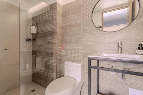 a bathroom with a toilet and a sink and a mirror at Soy Local Parque La 93 in Bogotá