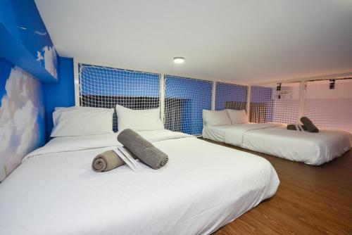 a hotel room with two beds with white sheets at Sunway Grid Loft Suite by Nest Home【Olympic Size Pool】 in Kampong Pendas